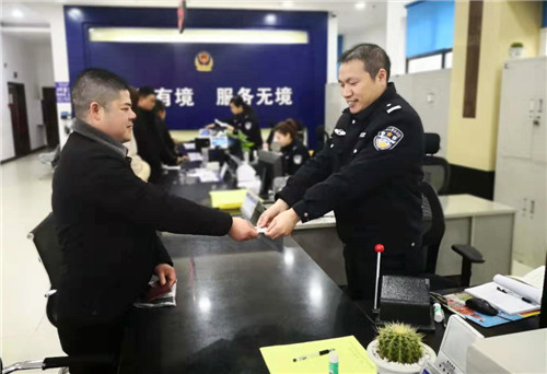 图二为王华林兴奋地领取刚办好的临时身份证.jpg