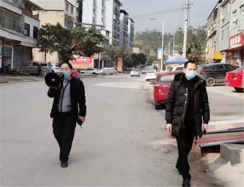 罗渡镇兴盛社区党委书记刘志强在街上用喇叭宣传疫情防控知识.jpg