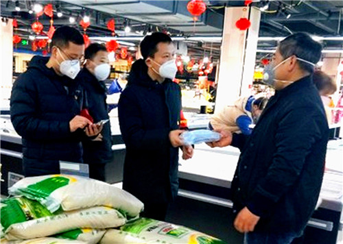 图为园区领导正在给超市人员免费发口罩.jpg