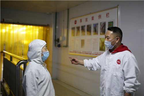 进车间前，黄建鲜向就业脱贫户喻辉交代上工注意事项。翁光建 摄.jpg