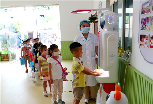5月6日，广安市广安区两路口幼儿园，机器人在为返校幼儿进行第二次晨检。当日，该幼儿园正式开学复课，学校采取分级分段、错时错峰组织学生入校复课。.jpg