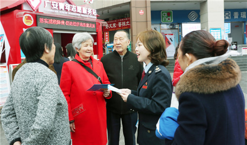 图为税务人员在街头讲解宣传.jpg