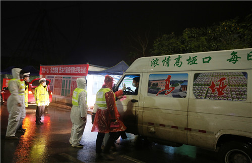 值守人员正在检查过路车辆给驾驶员测体温.jpg