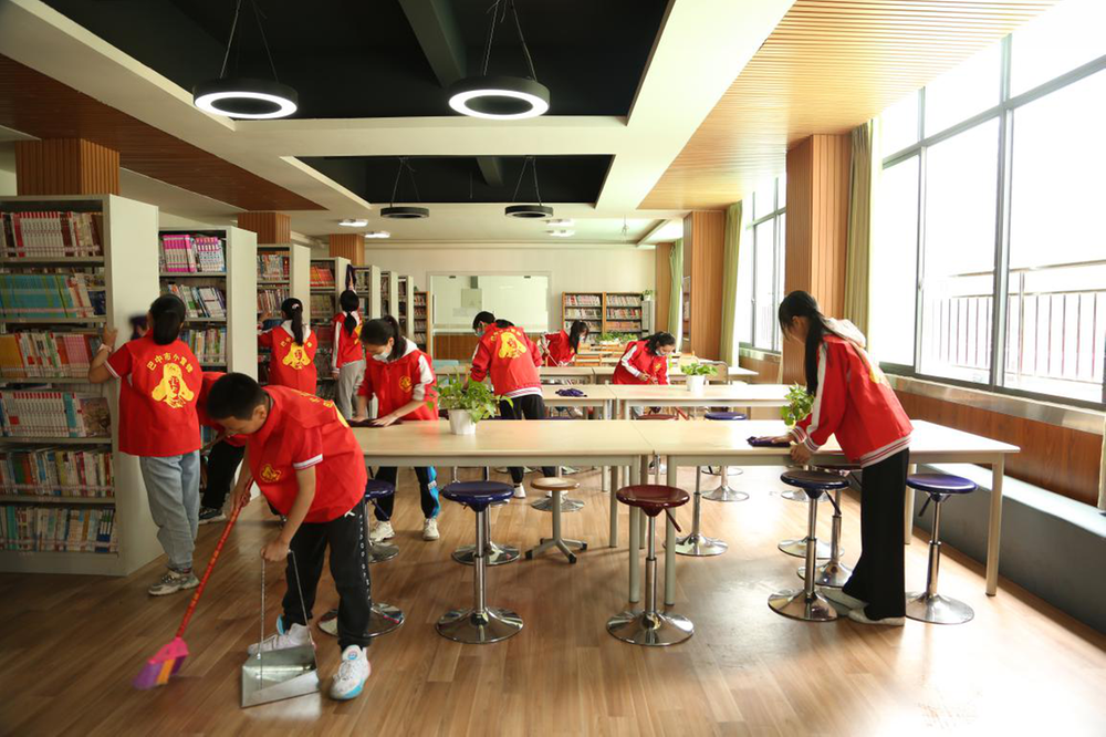 巴中市中坝小学“小雷锋”打扫整理校园图书馆